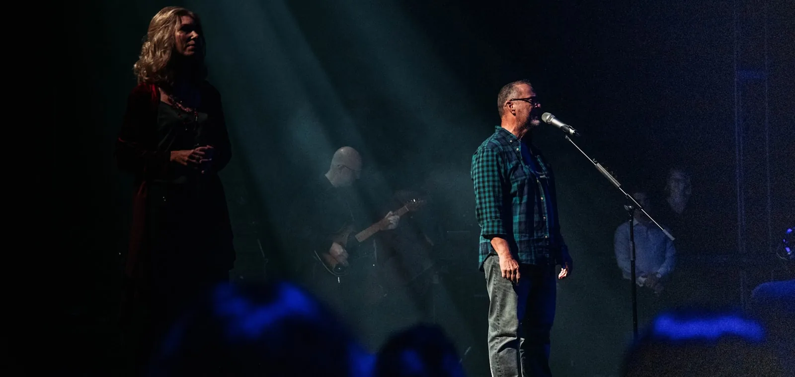 A musician performing on stage under a spotlight.